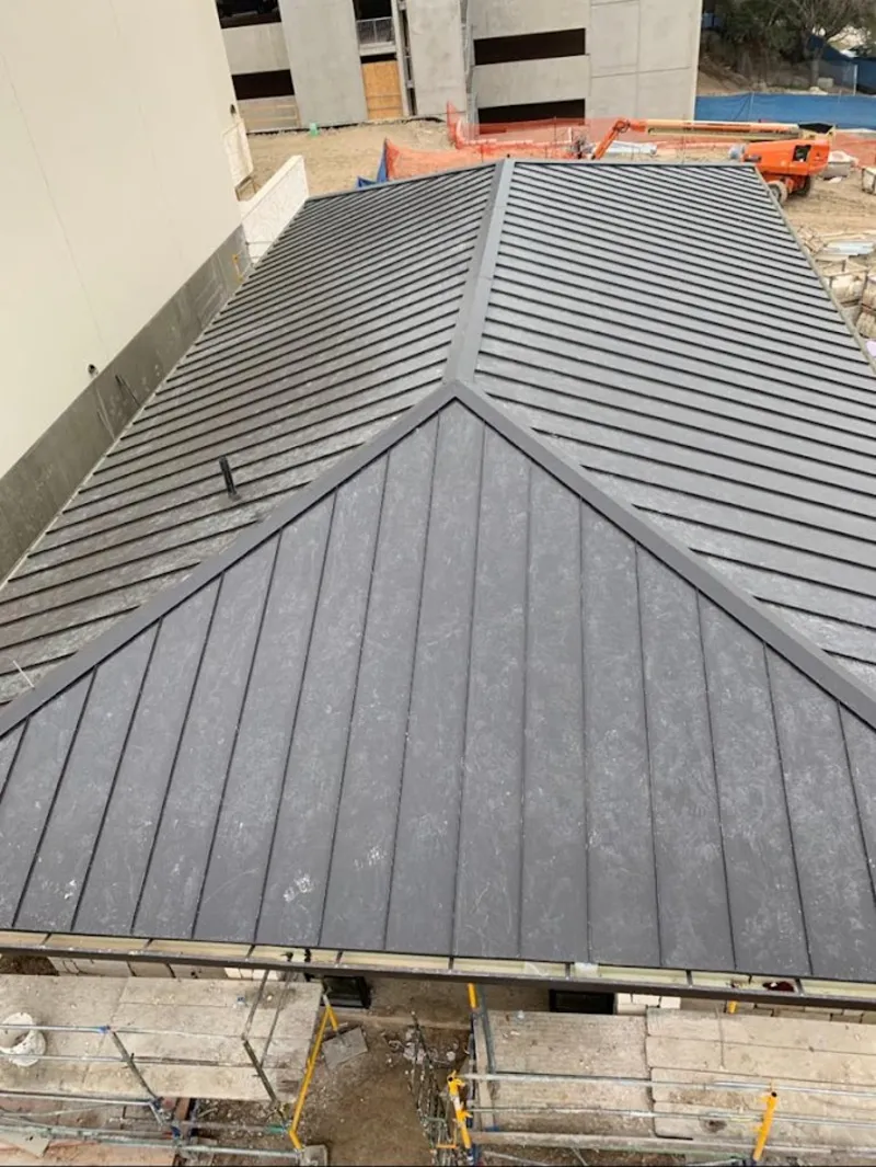 Commercial metal roof construction with crane equipment in Livingston